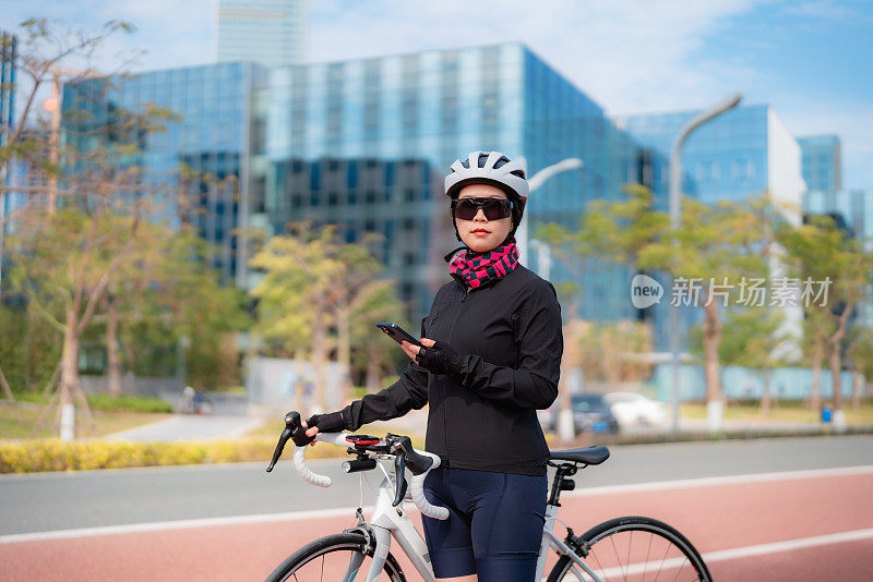 女公路自行车骑手使用智能手机