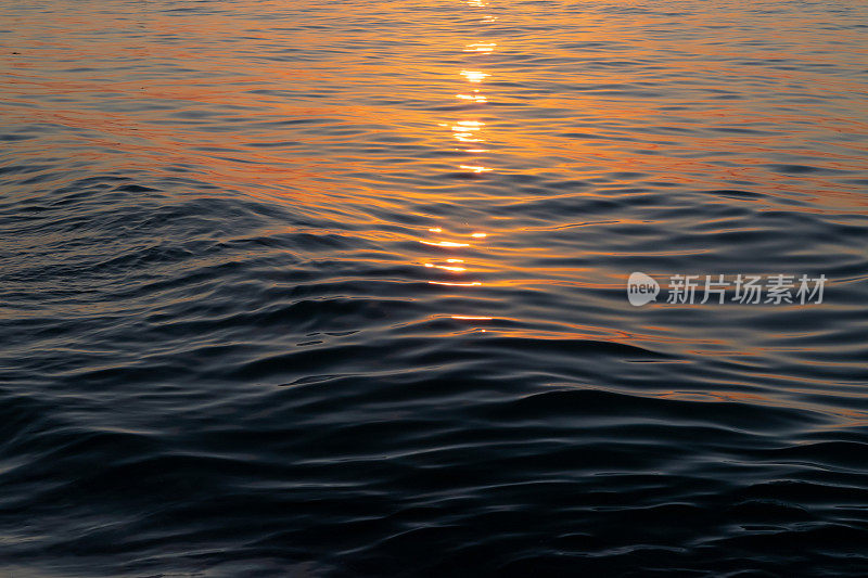 阳光刺眼地照在水面上。海上的夕阳。水面。