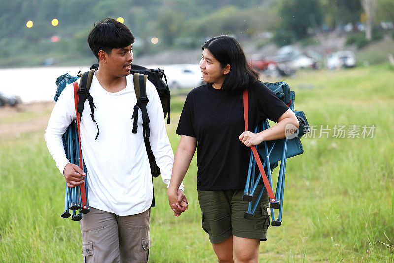 一对徒步旅行者在森林小径上。男男女女徒步旅行者在山上徒步旅行。一对年轻夫妇背着背包在森林里散步。