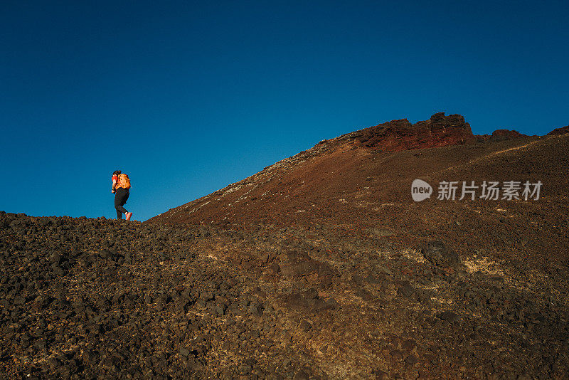 在火山景观中徒步旅行的女人，就像在火星上一样