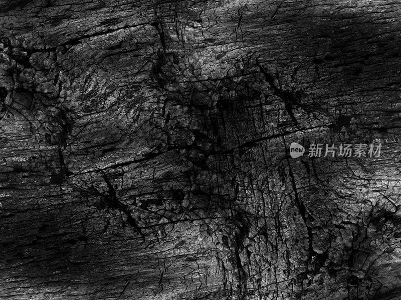 一棵黑色的老树的表面有明显的缺陷-皱纹不平等的沟槽-天然木板在长凳上的宏观