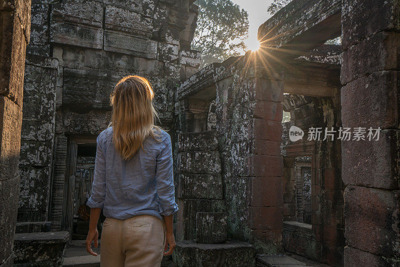 女游客漫游在古老的寺庙日落享受发现和旅游在亚洲，柬埔寨吴哥窟