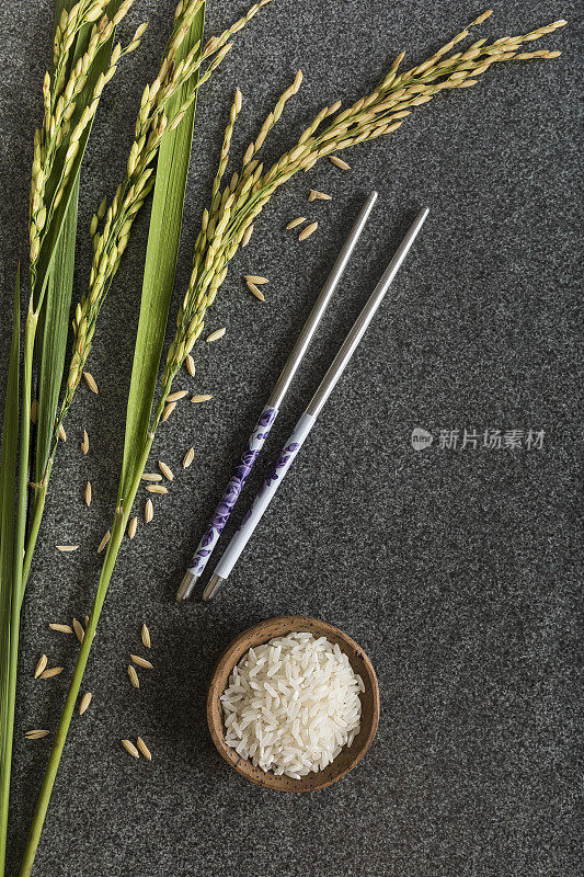 一碗白米饭，带有稻田茎和筷子