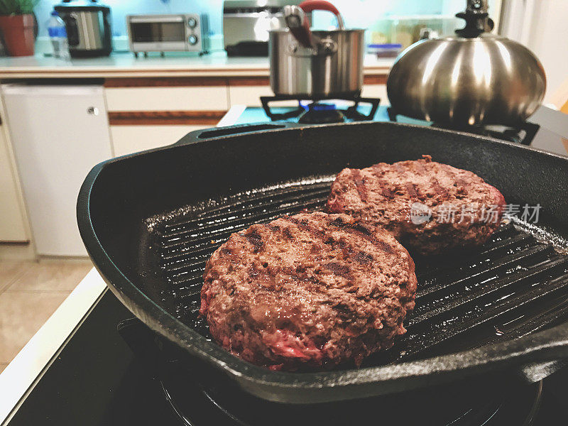 汉堡麋鹿汉堡肉饼在炉子上冷却在平底锅