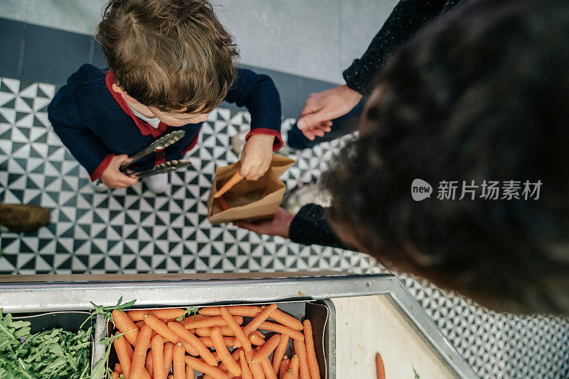 男孩在市场上挑选蔬菜