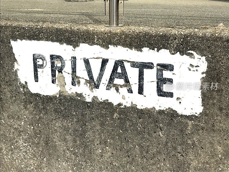 形象的私人标志张贴在混凝土墙上用白色油漆，警告标志关于私人财产，停车场通知人们