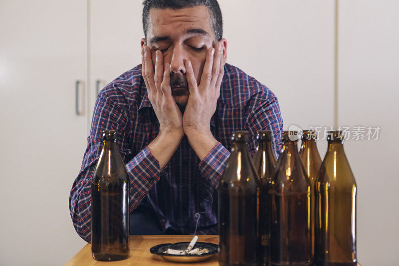 年轻悲伤的醉酒男子喝啤酒和酒精感到浪费，孤独和绝望的痛苦和情绪压力。人与酗酒、上瘾和男人抑郁的概念。