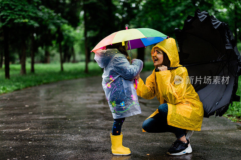 快乐的母女撑着伞散步