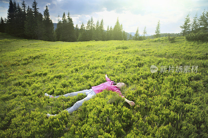 女人躺在山坡的草地上