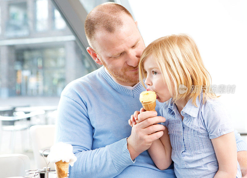 父亲和女儿在咖啡馆吃冰淇淋