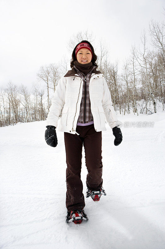 年轻女子穿着雪鞋走