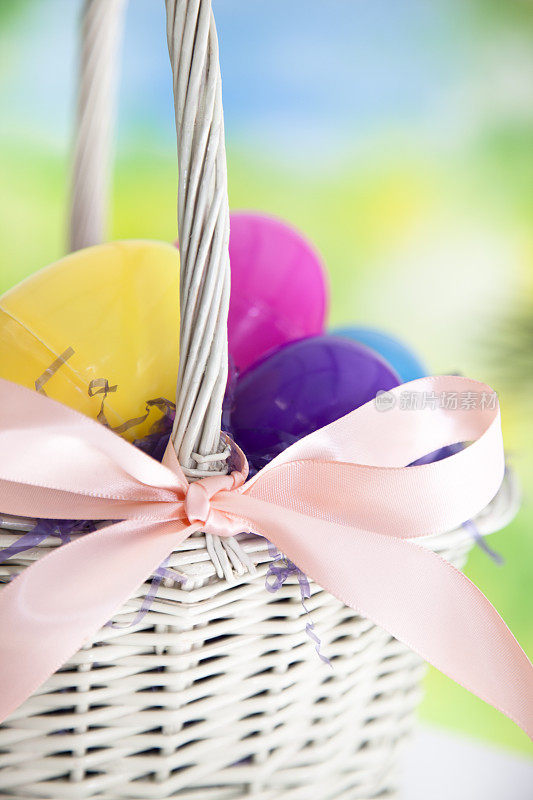 节日:用柳条篮子装复活节彩蛋，以彩色彩带为背景