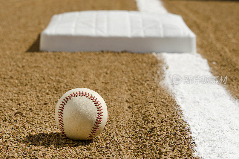 新棒球在一垒界外线的内野泥地上