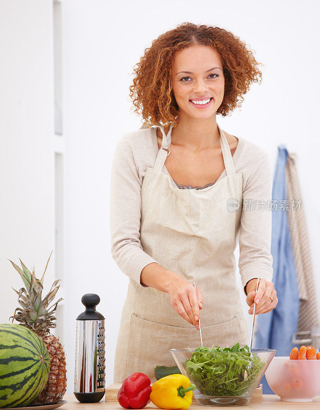 快乐的年轻女士在厨房做饭