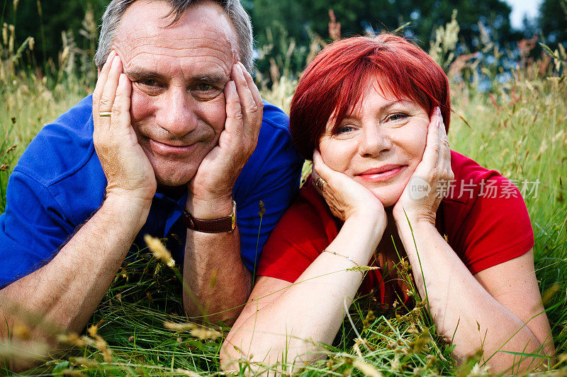 幸福成熟的夫妇躺在草地上，肖像
