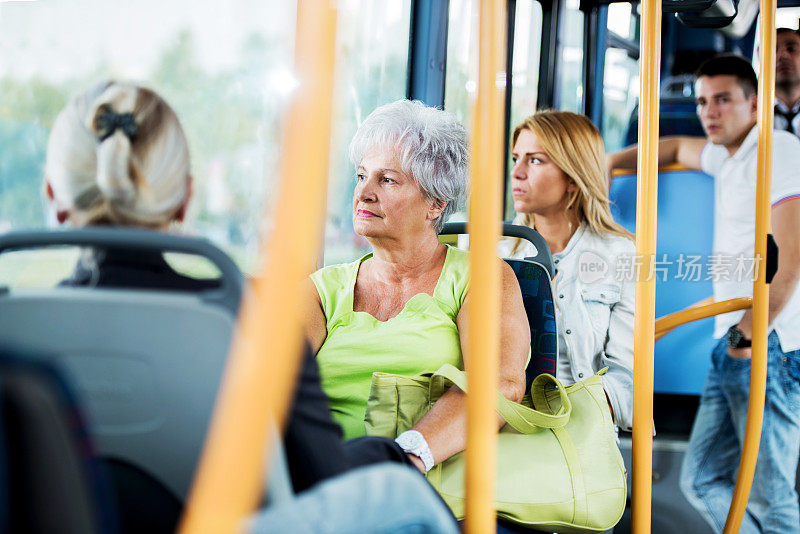 坐公交车上下班的老年妇女。