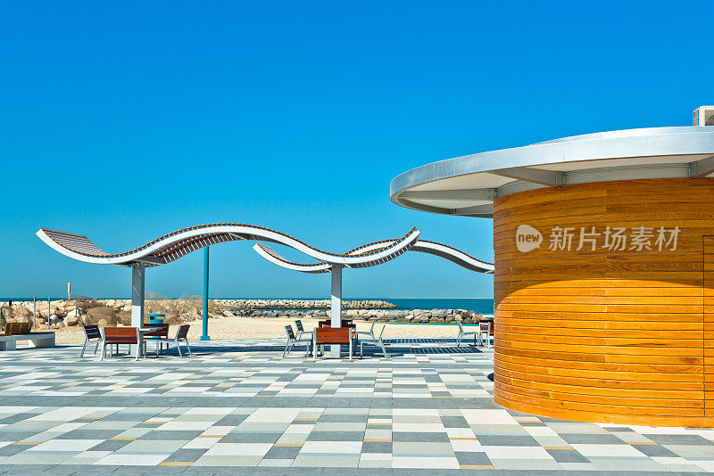 迪拜的现代海滩，有遮阳伞和长椅