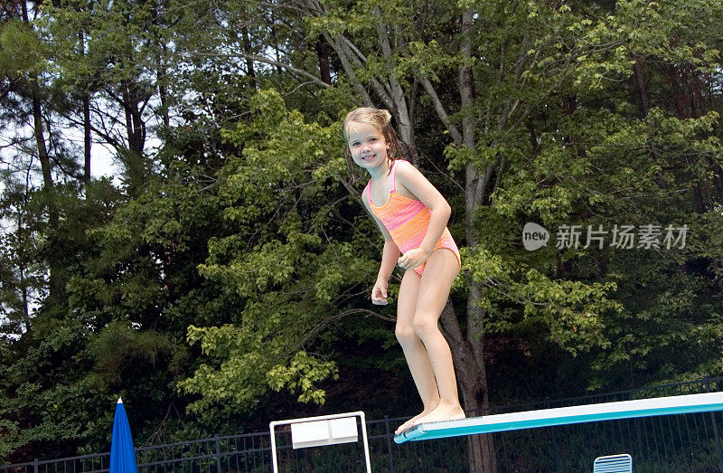 小女孩从跳水板上跳下来