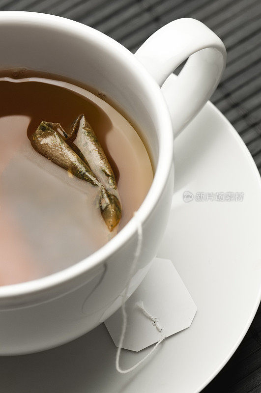 阿萨姆红茶和茶包在白色的茶杯和茶碟里