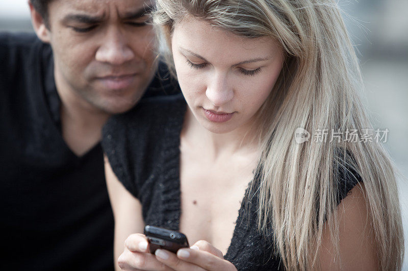 一对年轻夫妇在看手机短信
