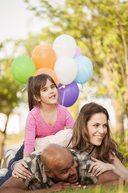 美丽的一家人在野餐时玩气球