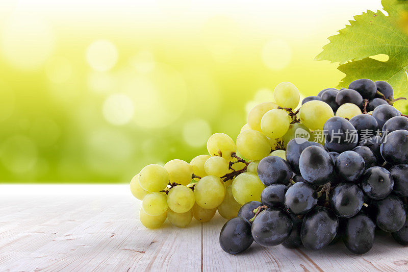 葡萄园里的桌子上有白葡萄和红葡萄