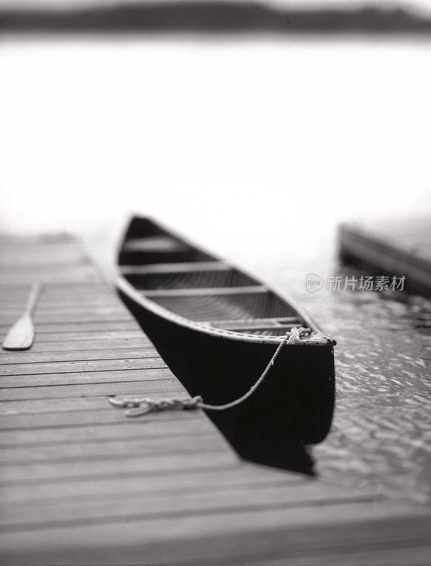 孤独，宁静:湖上码头上孤零零的独木舟