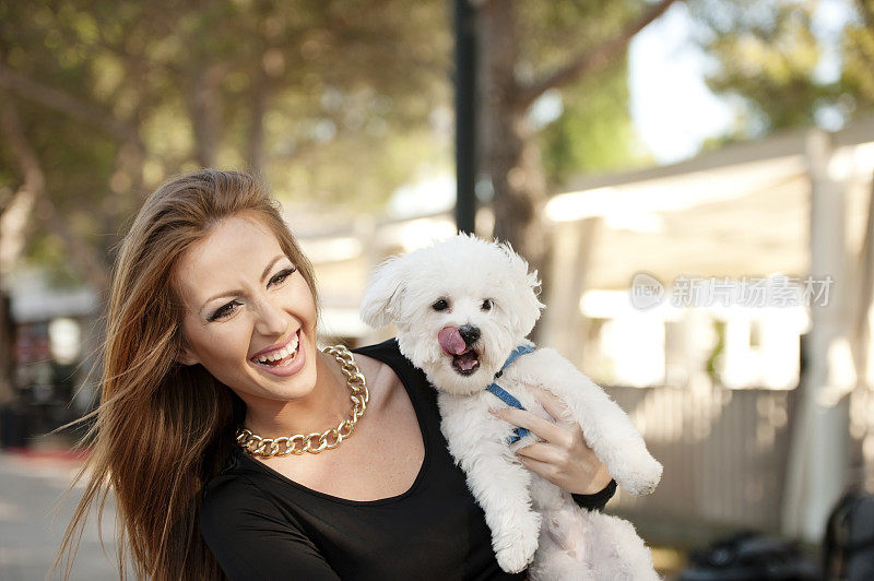 年轻微笑迷人的女人与马耳他贵宾犬