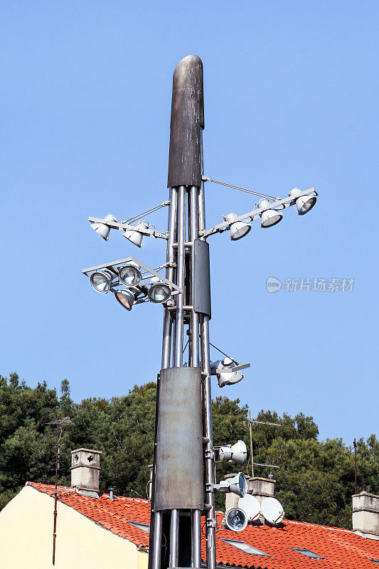 在城市道路和街道的环岛上有反射器的塔。蓝天灯杆。大灯和灯光的体育场杆子或体育照明。投光杆塔在聚光灯下。