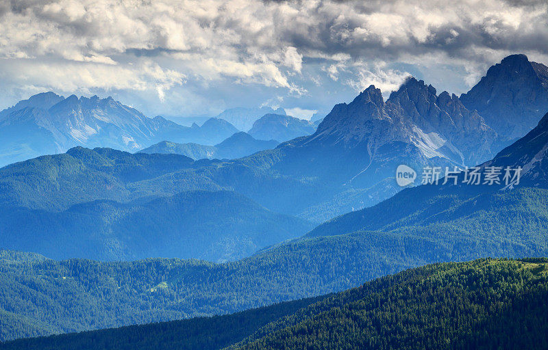 意大利多洛米提森林覆盖的山脊上有蓝雾和乌云