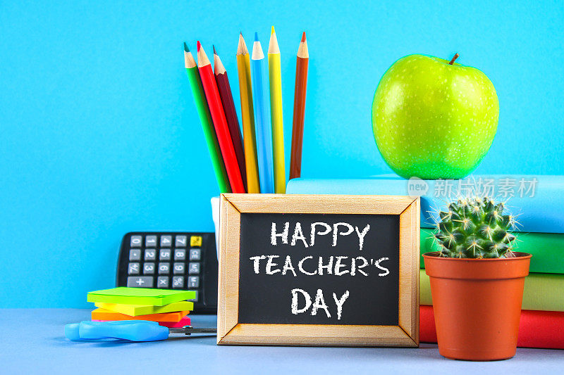 文字粉笔在黑板上:教师节快乐。学校用品，办公室，书籍，苹果。