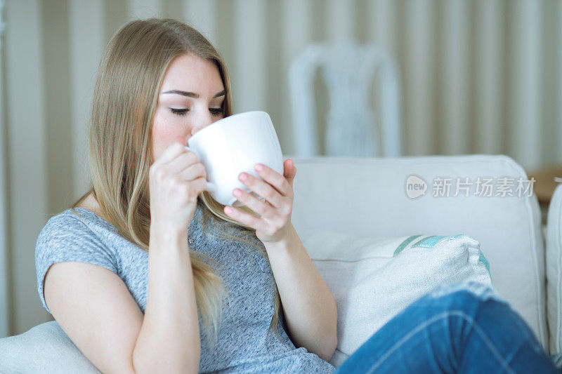 年轻女子在家里用一杯饮料