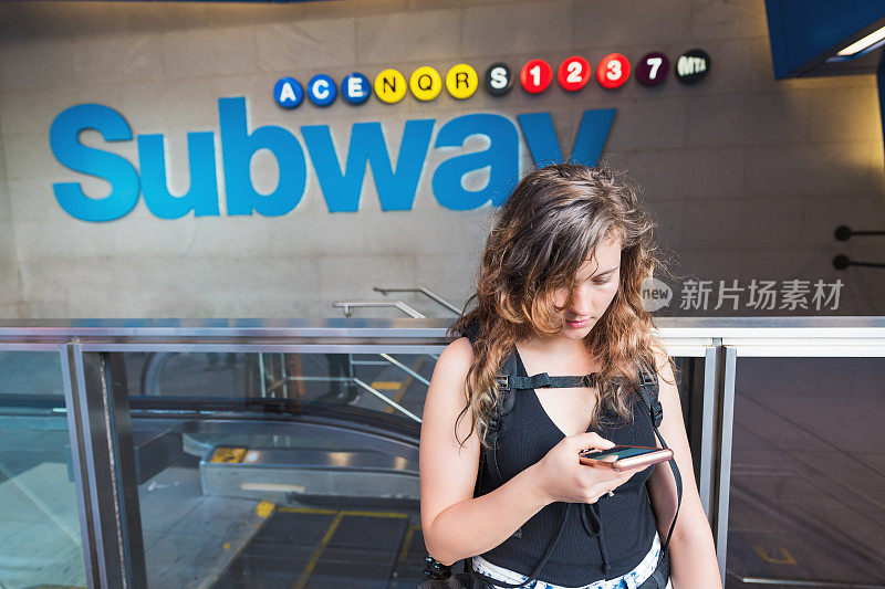 年轻的潮女千禧旅游女脸的特写，在纽约曼哈顿市中心的地铁上使用手机