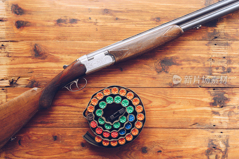 狩猎设备。木桌上放着猎枪和猎枪子弹。