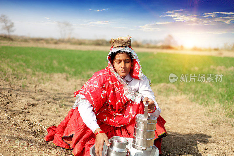 印度妇女坐在地里准备午餐
