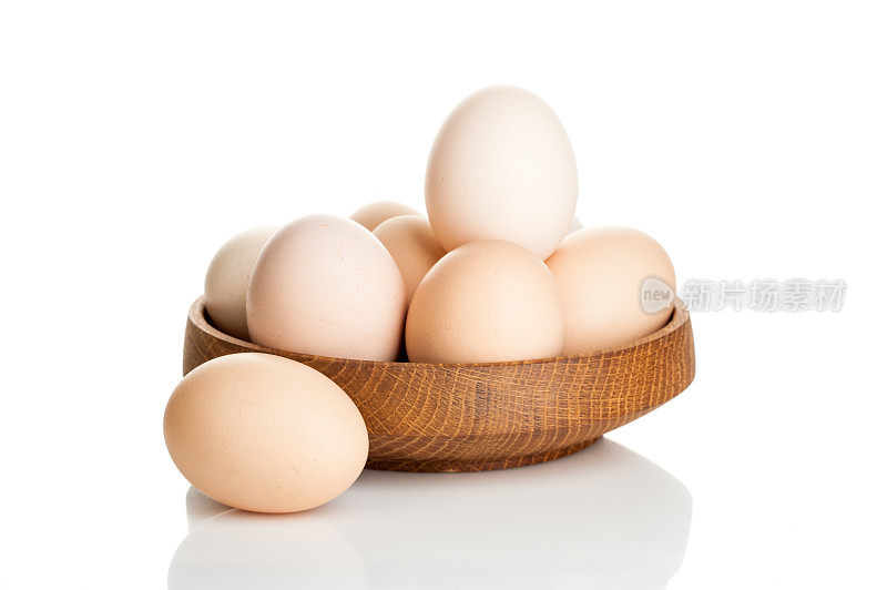 鸡蛋放在木盘里，孤立在白色背景上