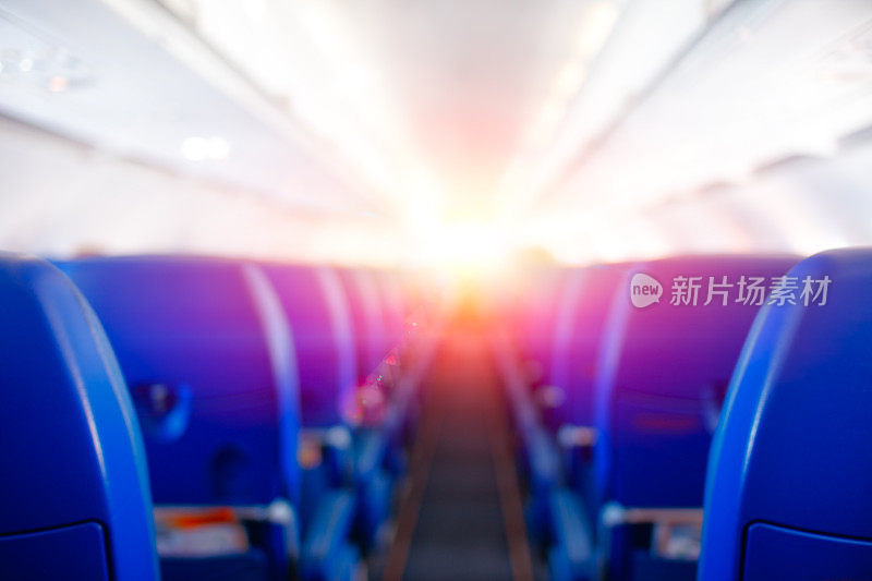 乘客座位，飞机内部，飞机飞行迎接阳光，明亮的阳光照亮飞机舱室，旅行的概念