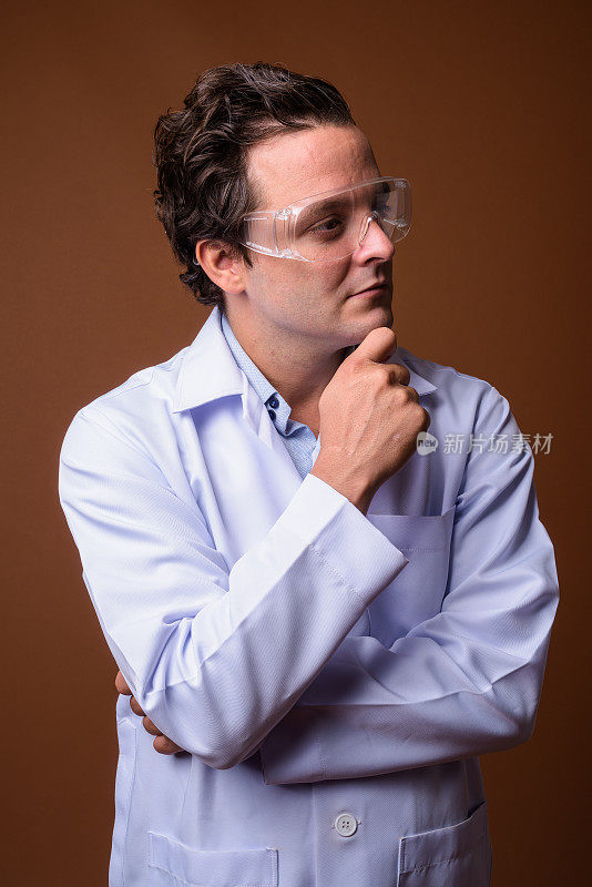 工作室拍摄的意大利男子医生戴着保护眼镜，以彩色背景
