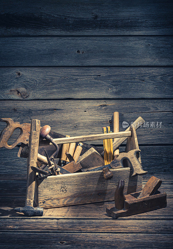 古色古香的木桌上放着一个旧细木工工具箱