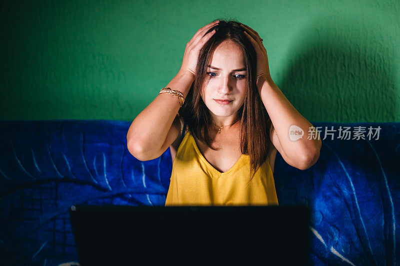 震惊的女人在晚上使用电脑