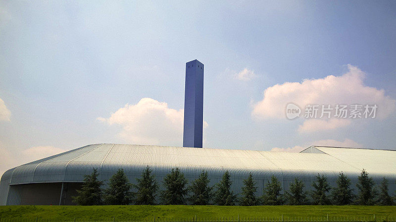 环保产业理念。工厂在清新的春天草地和蓝天的背景