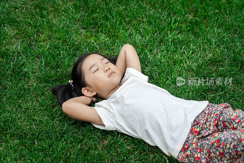可爱的女孩躺在草坪上