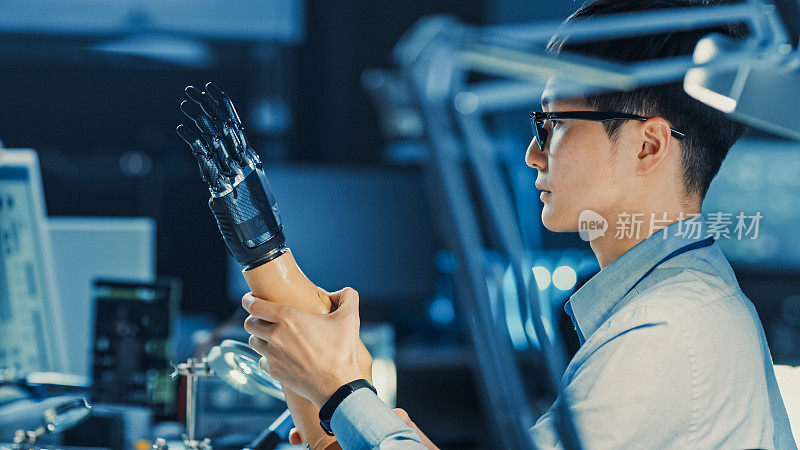 技术假肢机器人手臂是由两位专业开发工程师测试在一个高科技研究实验室与现代未来的设备。比较个人电脑数据