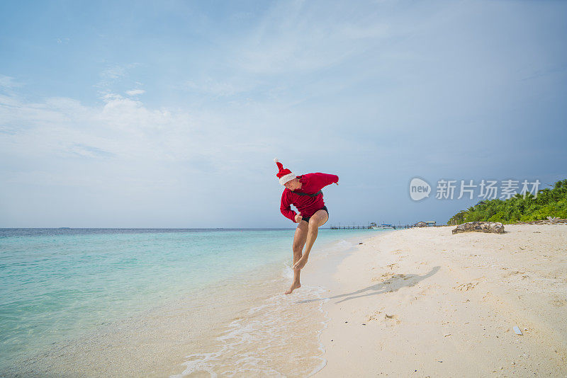 圣诞老人在马来西亚婆罗洲的太平洋沙滩上奔跑。