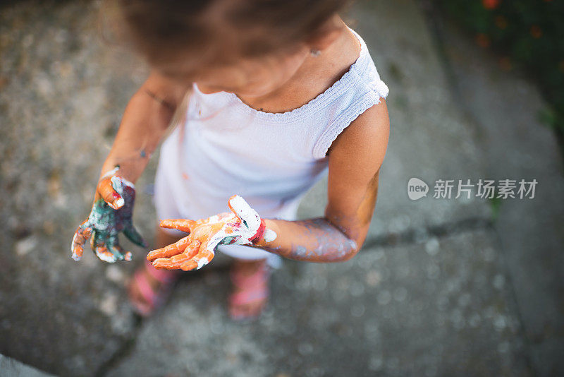 快乐的小女孩，手上涂着五颜六色的颜料