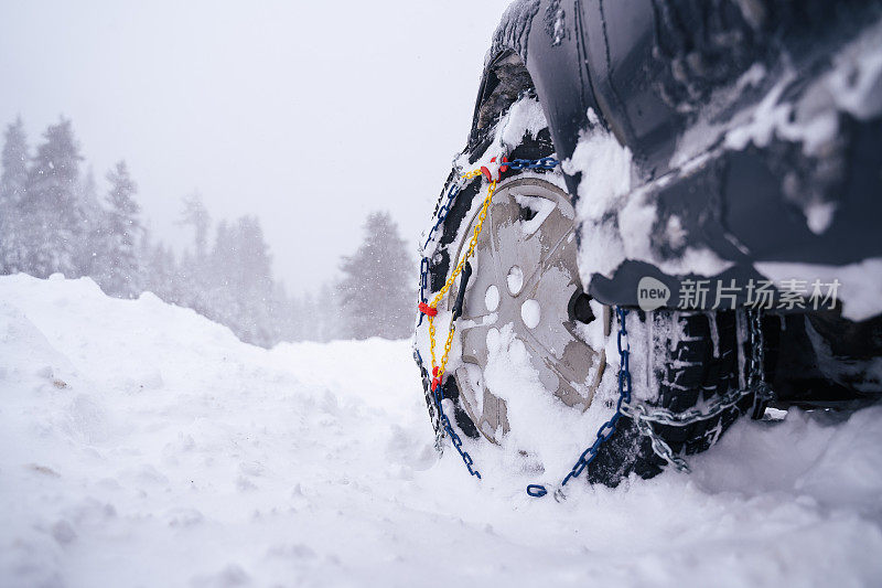 观点。冬天的轮胎在下雪的路上行驶。给轮胎上链子。冬天的道路安全。