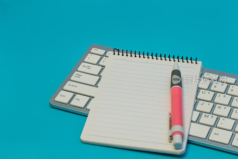 电脑键盘上的空白螺旋笔记本