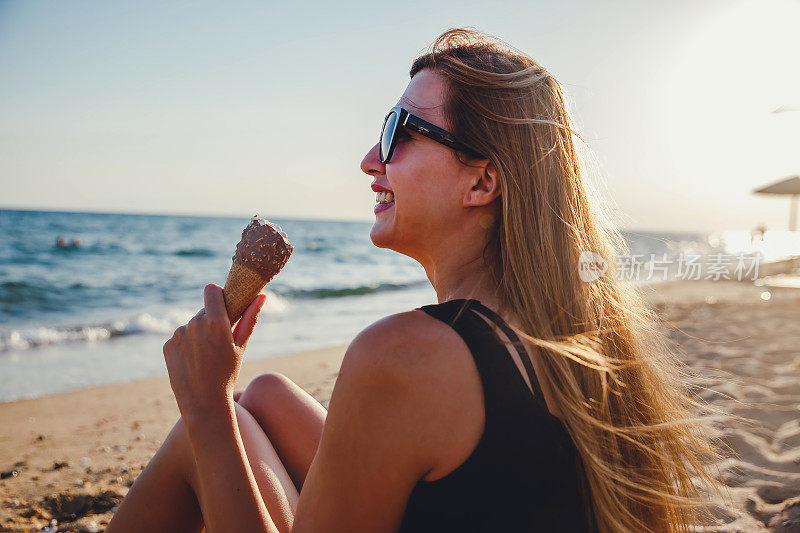 在海滩上吃冰淇淋的女人