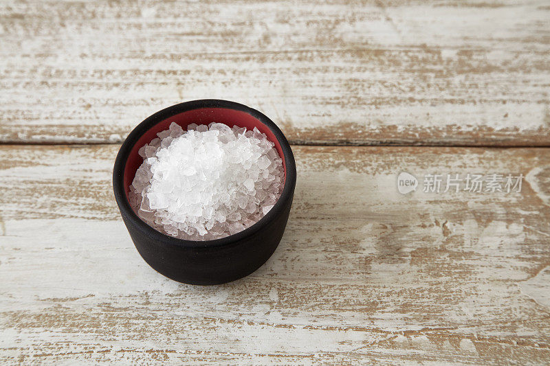 天然岩盐在木桌上的石碗里。