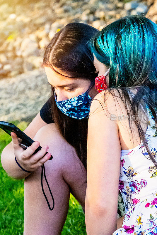 白人女孩使用保护面罩看智能手机